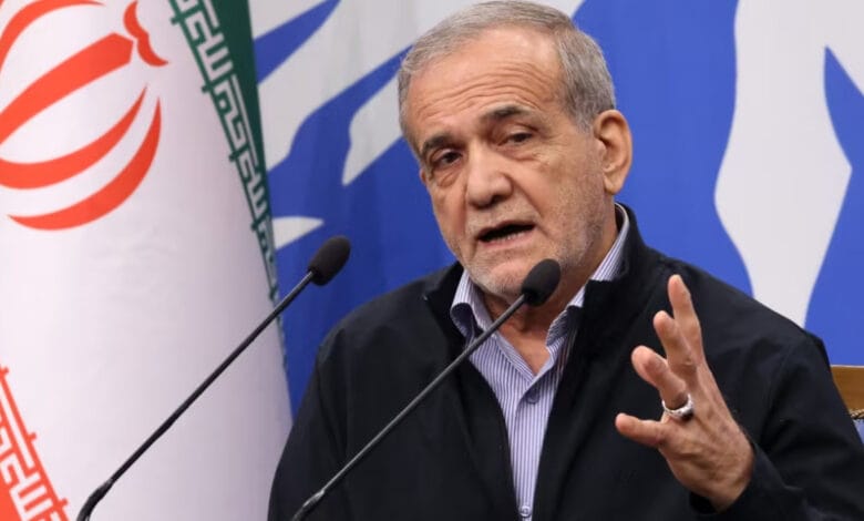 "ایرانی صدر مسعود پزشکیان اسلام آباد میں تقریب سے خطاب کرتے ہوئے، پس منظر میں پاکستان اور ایران کے جھنڈے اور حکومتی نمائندے موجود ہیں، موضوع دوطرفہ تجارت اور اقتصادی تعاون پر مبنی۔"